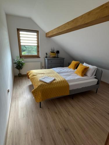 a bedroom with a bed with yellow sheets and a window at Osada Marcowa - Niebieski Domek z sauną & jacuzzi in Zakopane