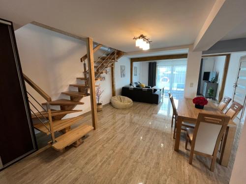 a living room and dining room with a spiral staircase at Osada Marcowa - Niebieski Domek z sauną & jacuzzi in Zakopane