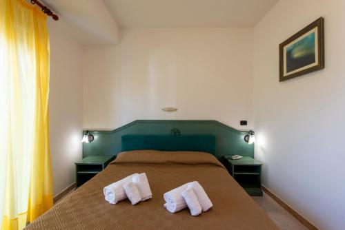 a bedroom with a bed with two towels on it at Villaggio Alkantara in Giardini Naxos