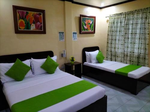 Bans Beach Resort في بوراكاي: سريرين في غرفة خضراء وبيضاء