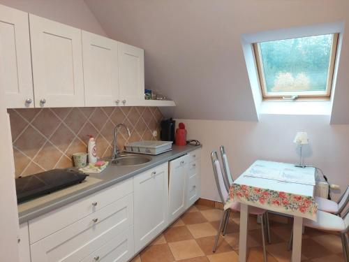 a kitchen with white cabinets and a table and a window at Apartament Vistula in Wisła