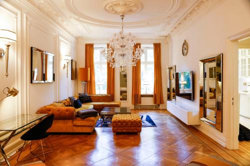 a living room with a couch and a chandelier at Sleephotels Alsterroom in Hamburg