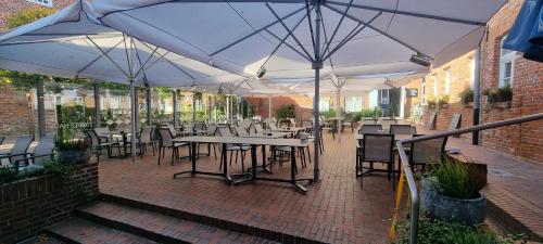 an outdoor patio with tables and chairs and umbrellas at Hohes Haus in Greetsiel