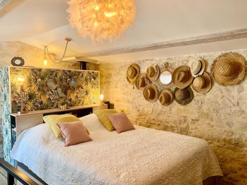 una camera da letto con un letto con cappelli appesi al muro di Maisonnette atypique cadarache-iter a Saint-Paul-lès-Durance
