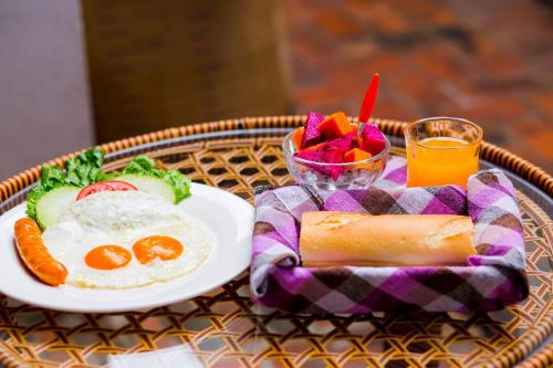 - un plateau de petit-déjeuner composé d'œufs et de légumes ainsi qu'un verre de jus d'orange dans l'établissement Mekong Charm Riverside, à Luang Prabang