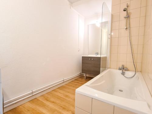 Un baño blanco con bañera y lavabo. en Appartement moderne 3 pièces à Flaine, capacité 6 personnes - FR-1-425-3, en Flaine