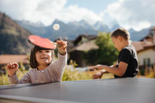 a little girl wearing a hat on top of a table at Hotel La Montanara Predazzo in Predazzo