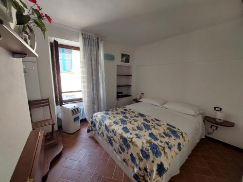 a bedroom with a bed with a blue and white blanket at A cà di Bafirussi in Vernazza