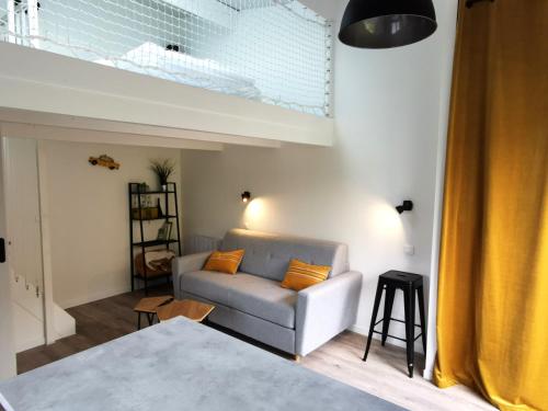 a living room with a couch and a window at L Annexe - Studio avec Piscine Privee in Les Sables-d'Olonne