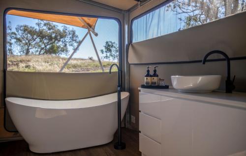 a bathroom with a tub and a sink at Sierra Escape Luxury Glamping in Piambong