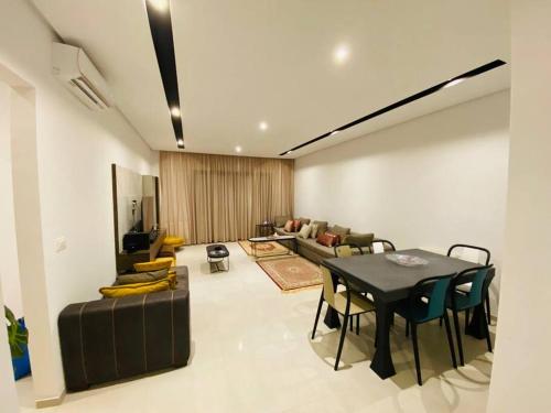 - un salon avec une table et un canapé dans l'établissement Sousse Sahloul apartment de luxe 10 min de la mer, à Sousse
