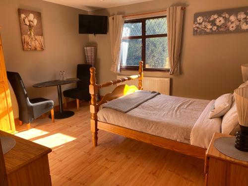 Schlafzimmer mit einem Bett, einem Tisch und einem Fenster in der Unterkunft Davmar House in Cork