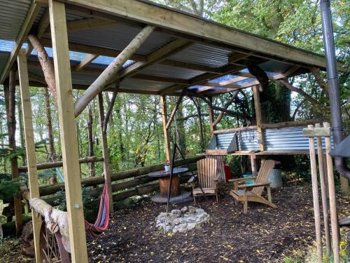 a wooden pergola with a table and chairs under it at The Hobbit House and Secret Garden in Taunton
