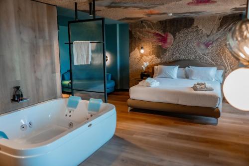 a bedroom with a large tub and a bed at Spirit Hotel Ciudad de Burgos in Rubena