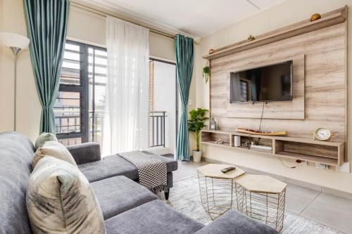 a living room with a couch and a tv at The Resting Nest Havilla in Midrand