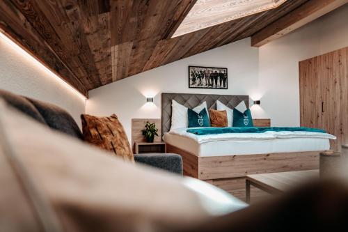 - une chambre avec un lit et une chaise dans l'établissement Tanners Chalet Apartments, à Altenmarkt im Pongau
