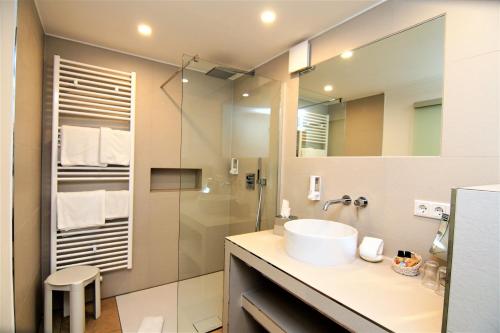 La salle de bains est pourvue d'un lavabo et d'une douche. dans l'établissement Landhotel Schöll, à Parsberg