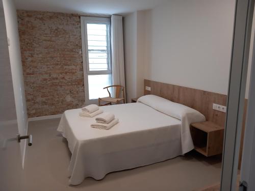 um quarto com uma cama branca e uma janela em Vora Salou em Salou