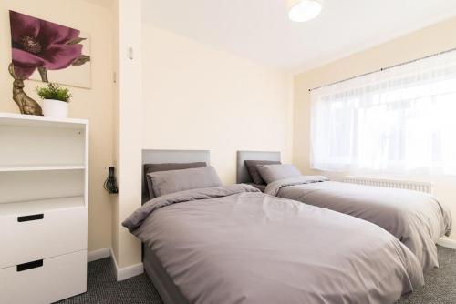 1 dormitorio con 2 camas y ventana en City Home from Home - Peaceful, Cosy & Modern 2Bed house en Nottingham