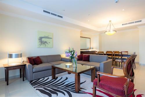 a living room with a couch and a table at Sedra Arjaan by Rotana in Doha