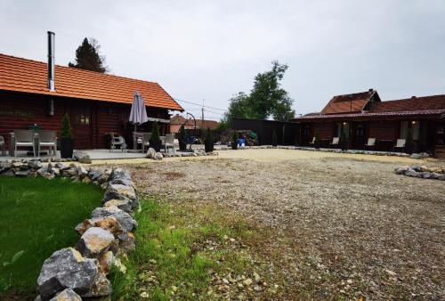 a yard in front of a building with a stone wall at Odmaraliste Kod Miće Apartman 4 in Krušar