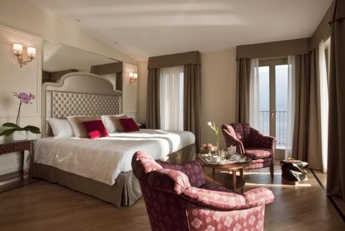 a hotel room with a bed and two chairs at Hotel Villa Flori in Como