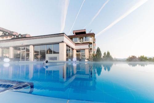 ein großes Gebäude mit einem Pool davor in der Unterkunft Avita Resort Bad Tatzmannsdorf in Bad Tatzmannsdorf