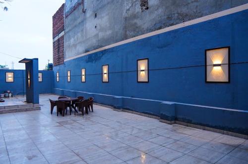 a blue wall with tables and chairs on a patio at HOTEL PLAZA GRAND in Jalandhar
