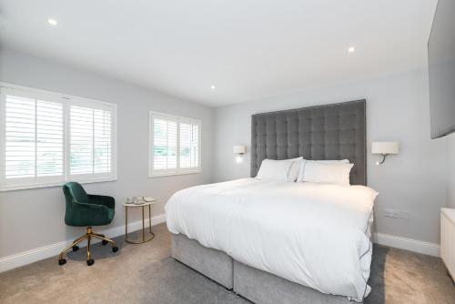 a bedroom with a large bed and a green chair at Albert Rooms in Dublin