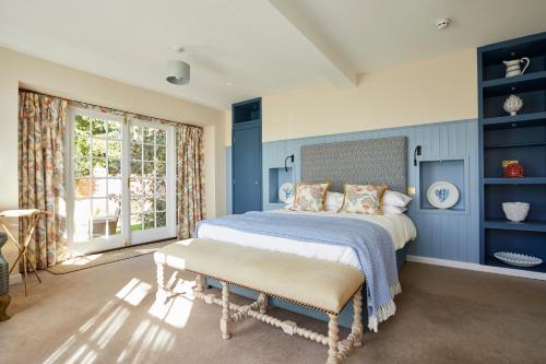 a bedroom with blue walls and a bed with a bench at The Royal Oak, Yattendon in Frilsham