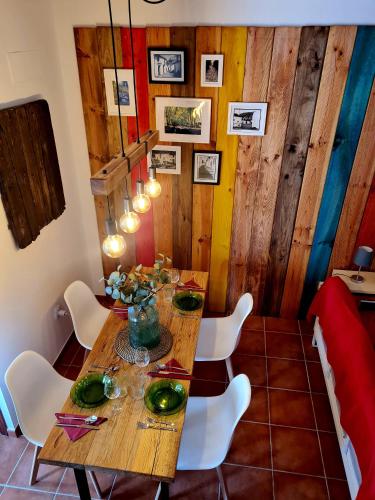a dining room with a wooden table and white chairs at La Casa Junto al Sendero del Río & Piscina # aire acondicionado in Los Romeros