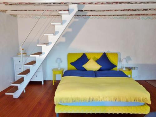 a bedroom with a yellow bed and a staircase at Ferienhaus Turilji in Albinen