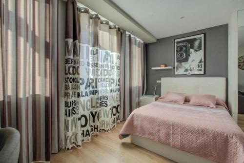 Apartamento loft en plaza España - gran vía في مدريد: غرفة نوم بسرير وجدار عليه كلام