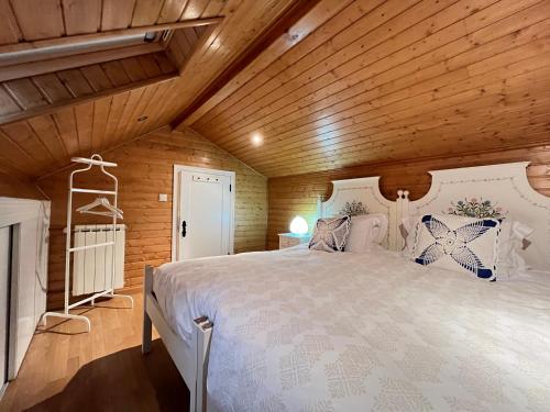 a bedroom with a large bed in a wooden ceiling at Casa do Rolo by Trip2Portugal in Montalegre