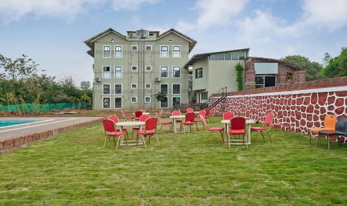 a group of tables and chairs in front of a building at Treebo Vhyomaan Resort in Mahabaleshwar