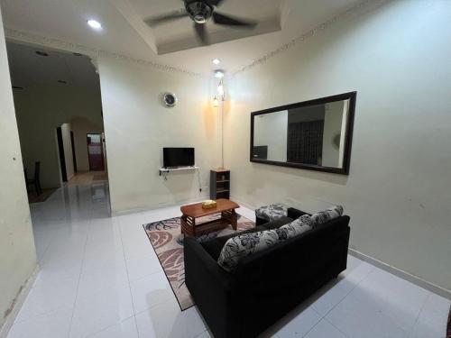 a living room with a couch and a flat screen tv at Cendana Residence Homestay Pengadang Baru Kuala Terengganu in Kuala Terengganu