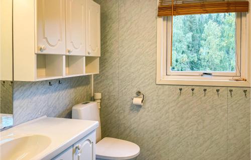 a bathroom with a sink and a toilet and a window at Lovely Home In yer With House A Mountain View in Øyer