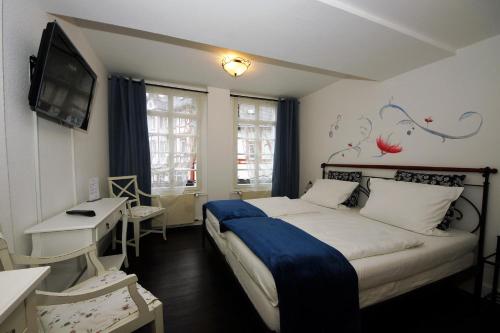 Dormitorio con cama, escritorio y TV en Liebezeit - ehemals Hotel Dillenburg, en Dillenburg