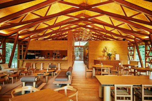 輕井澤的住宿－SHISHI-IWA-HOUSE Karuizawa，餐厅设有木制天花板和桌椅