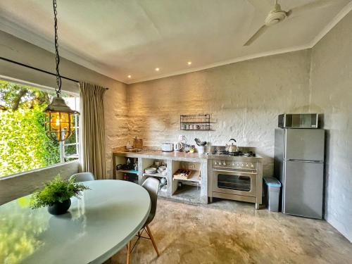 a kitchen with a table and a refrigerator at Chocolate Orchid in White River