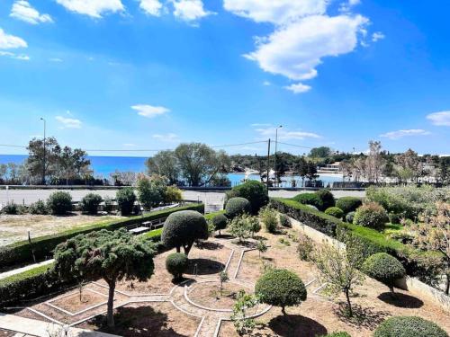 un jardin avec des arbres et des buissons dans un parc dans l'établissement Lagonisi 2 bedroom luxury Apartment by the sea!, à Lagonissi