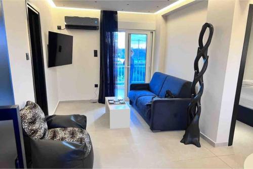 uma sala de estar com um sofá azul e uma cadeira em Lagonisi 2 bedroom luxury Apartment by the sea! em Lagonissi