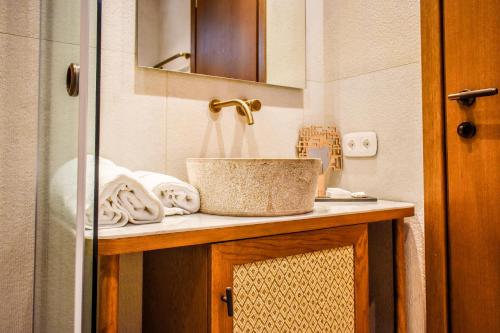 a bathroom with a sink and a basket on a counter at Mandraki Village Boutique Hotel in Koukounaries