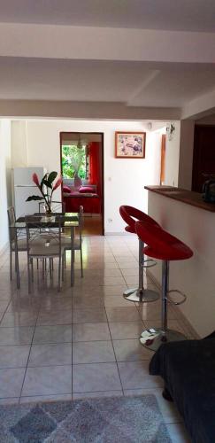 a living room with a table and chairs and a kitchen at Appartement moderne au cœur de Le Robert, 45m², balcon privé in Le Robert