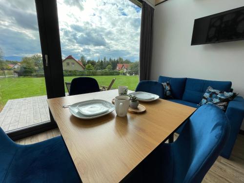 une table et des chaises en bois avec une table et une fenêtre dans l'établissement Zakątek na Lipowej, à Komarno