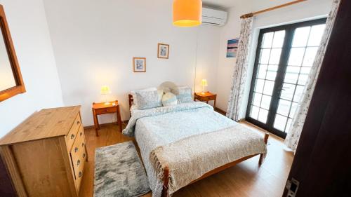 een slaapkamer met een bed en een groot raam bij Albufeira Calipto by Sunny Deluxe in Albufeira