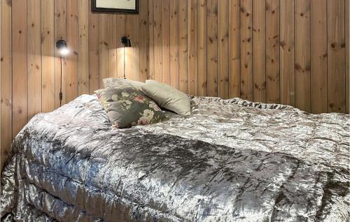 1 cama con 2 almohadas en un dormitorio con paredes de madera en Amazing Apartment In Sjusjen With House A Panoramic View en Sjusjøen