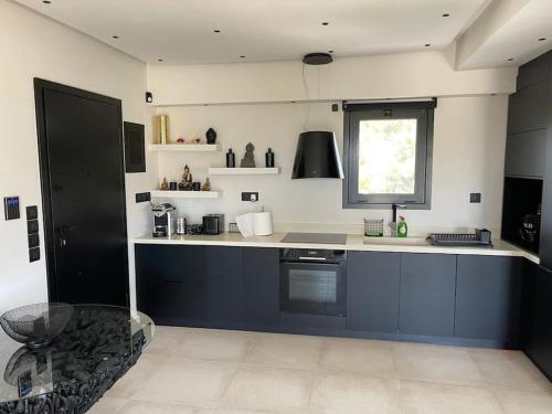 een keuken met een blauw-wit aanrecht en een raam bij Lagonisi Luxury appartment 2 by the sea in Lagonissi