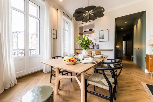 een eetkamer met een houten tafel en stoelen bij HYGGE KEYWEEK Apt 2 bedrooms with parking in Biarritz city center in Biarritz