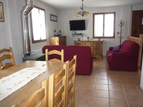 sala de estar con mesa y sofá rojo en Casa Rural Ezkibel, 